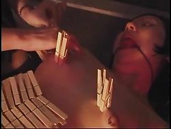 BDSM bitch drips hot wax on petite bondaged Asian with red ball in mouth